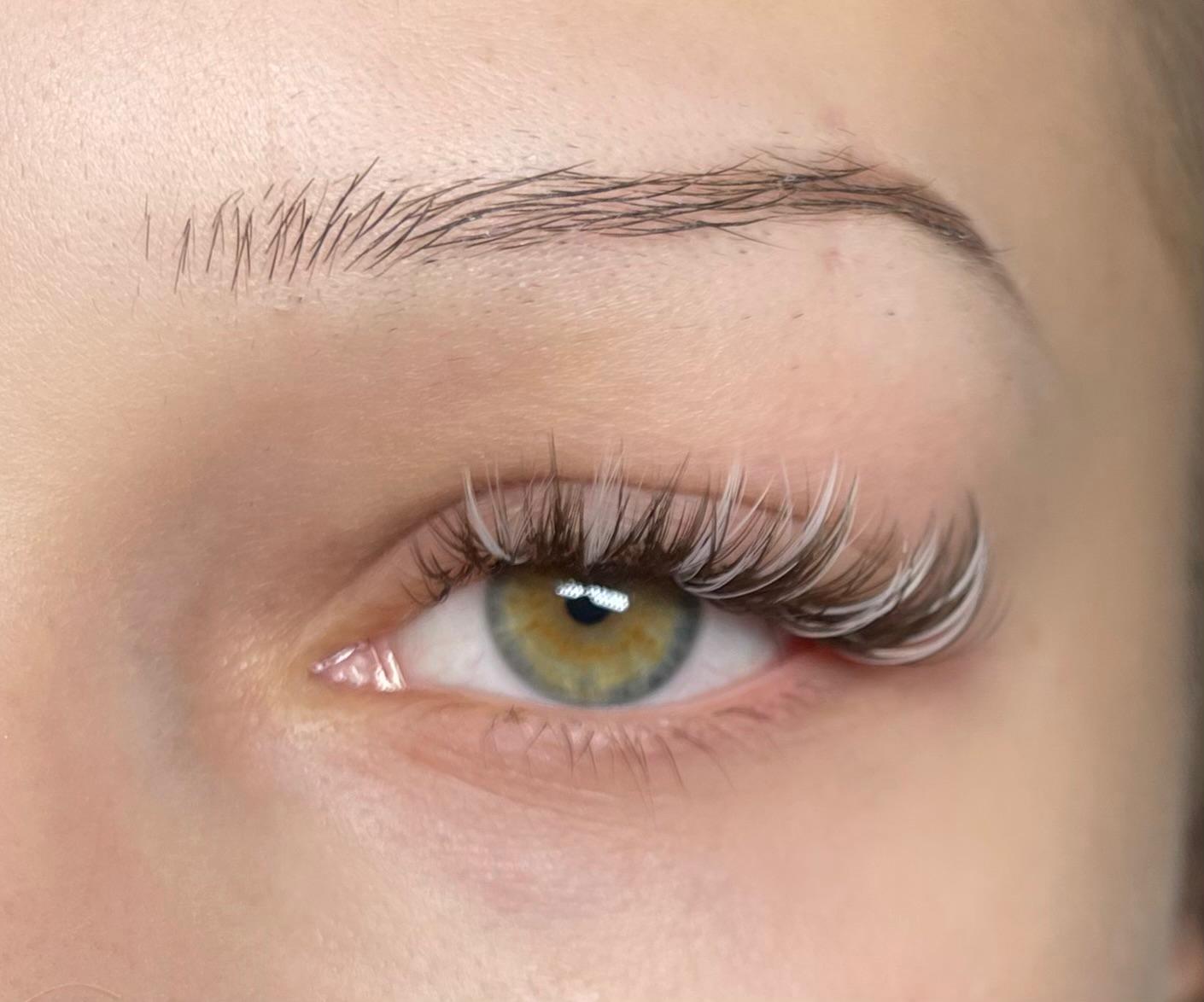 Farbige Wimpern mit weißen Akzenten, Großaufnahme eines Auges